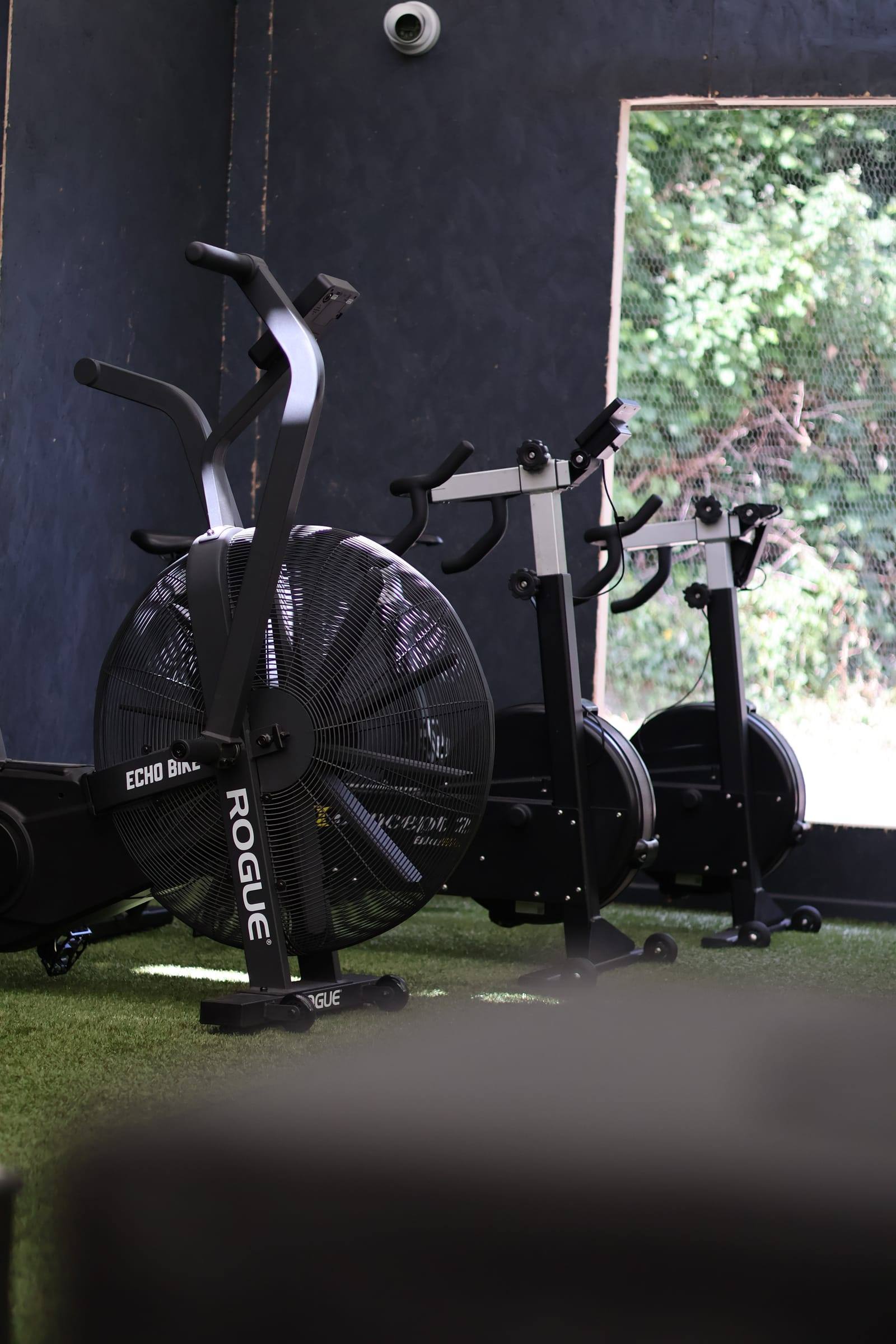 Air bikes lined up on turf in the Bristol conditioning area
