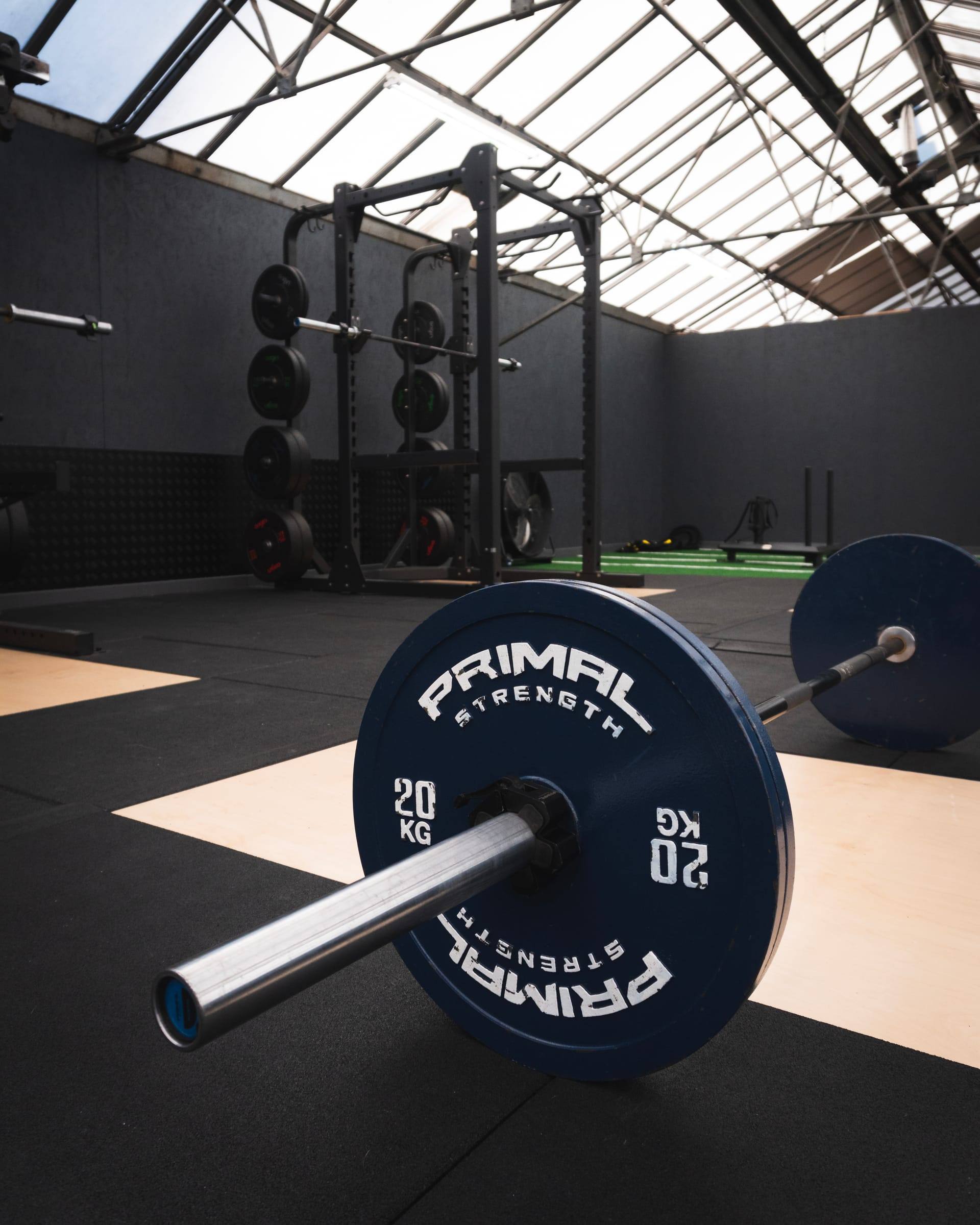 Loaded barbell with a 20 kg plate resting on a lifting platform at Base Gym Bristol