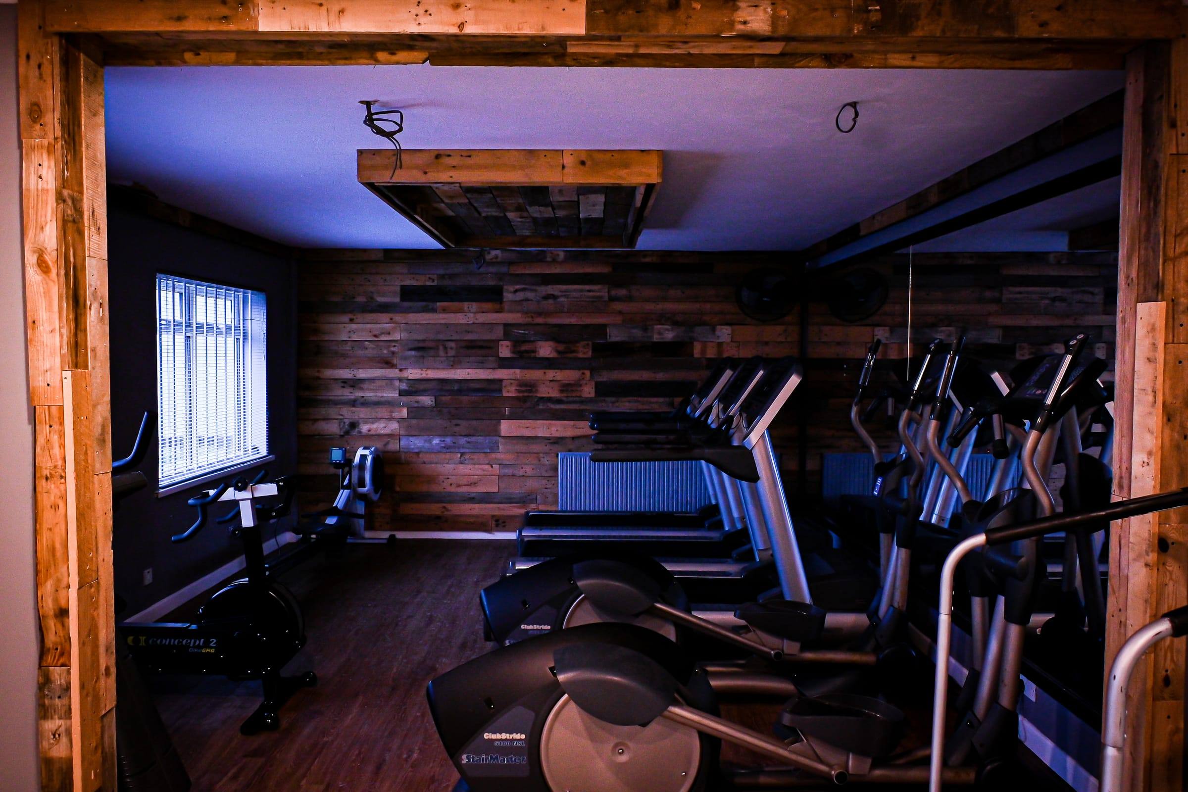 The Yeovil cardio room: treadmills and cross-trainers against reclaimed timber walls