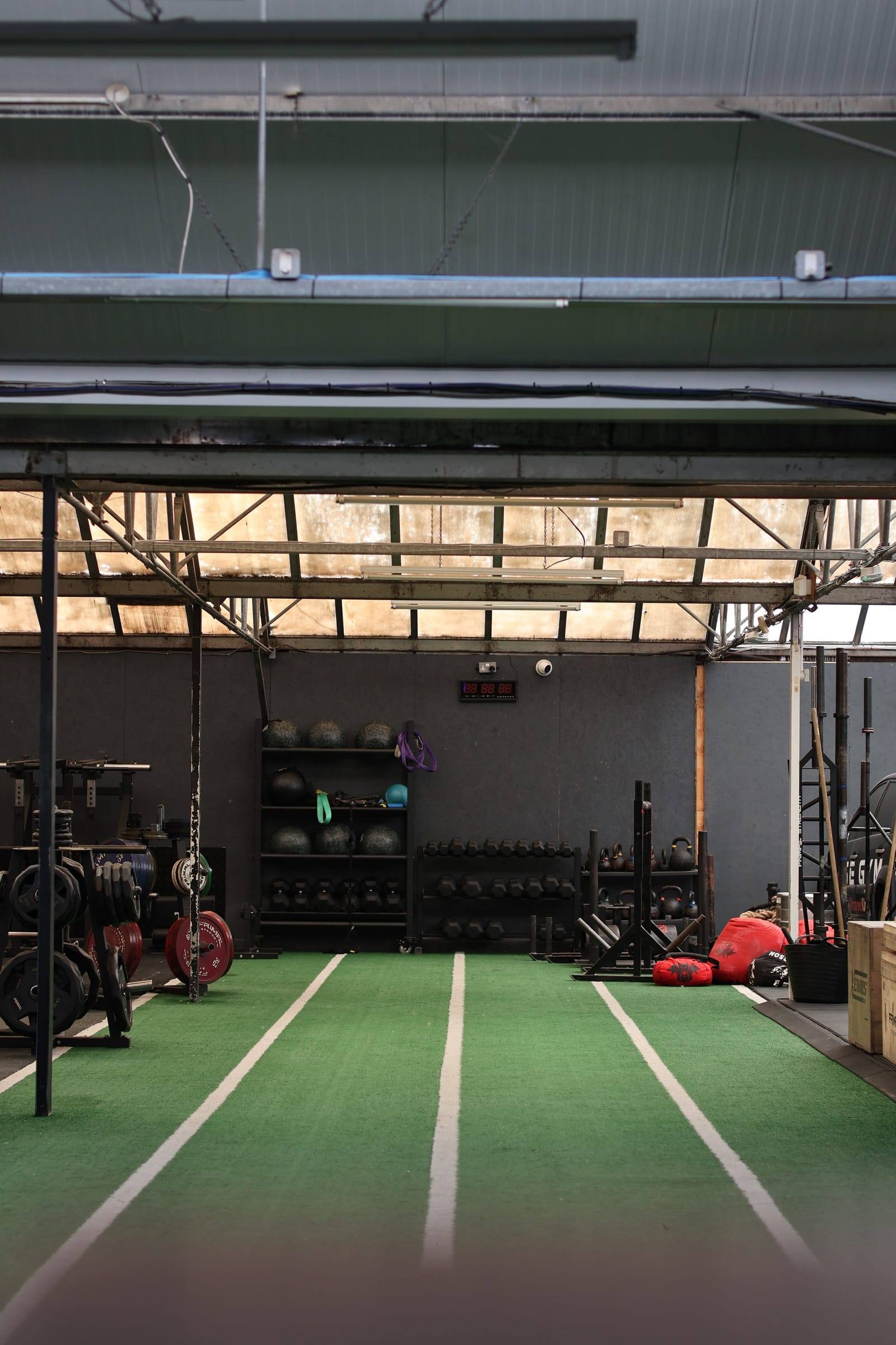 Turf sled track running the length of the Bristol functional area, with medicine balls and kettlebells beyond